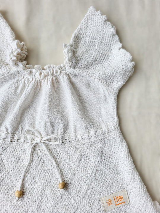 Liten Aventuris brand. Make a statement with the Annie Blouse! Crafted from soft cotton and featuring a playful knitted cotton pattern with drop-short sleeves. This blouse is perfect for any summer adventure. Prepare them for sunshine and comfort with fresh style. Perfect for girls. Barnkläder, Bomullskläder, Natural kläder. Flicka kläder. Flickblus. Barnblus.