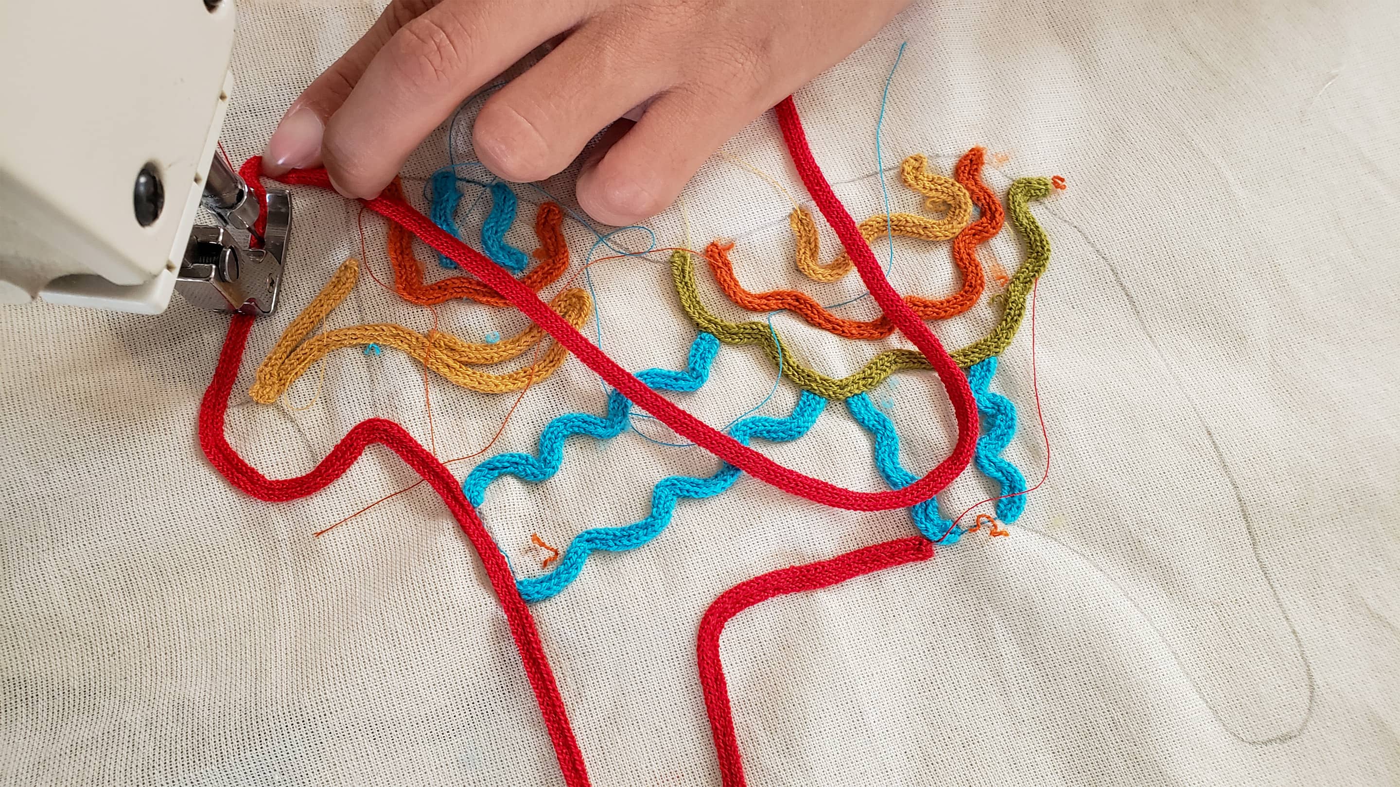 Artisanal embroidery of a Dala horse on a sustainable children's t-shirt by Liten Aventuris. | Hantverksmässig brodyr av en Dalahäst pü en hüllbar barn t-shirt av Liten Aventuris. | Bordado artesanal de un caballo Dala en una camiseta sostenible para niùos de Liten Aventuris.