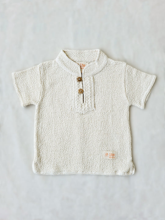 Liten Aventuris Collections. This crafted Luigi Shirt is made of 100% knitted natural Peruvian cotton for a comfortable and lightweight fit. This classic shirt features a mao collar with wooden buttons and a beautifully knitted honeycomb pattern in the opening. It has two apertures on the sides and is finished with knitted trims around the sleeves and base. The loose fit makes it comfortable and perfect for playing. Bomullskläder, barnkläder, Pojken tröja, Skjortor, Natural kläder, ekologisk kläder.