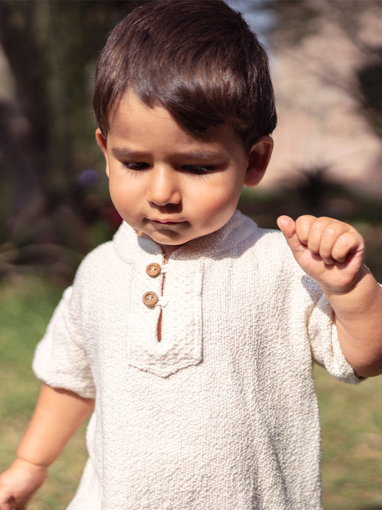 Liten Aventuris Collections. This crafted Luigi Shirt is made of 100% knitted natural Peruvian cotton for a comfortable and lightweight fit. This classic shirt features a mao collar with wooden buttons and a beautifully knitted honeycomb pattern in the opening. It has two apertures on the sides and is finished with knitted trims around the sleeves and base. The loose fit makes it comfortable and perfect for playing. Bomullskläder, barnkläder, Pojken tröja, Skjortor, Natural kläder, ekologisk kläder.