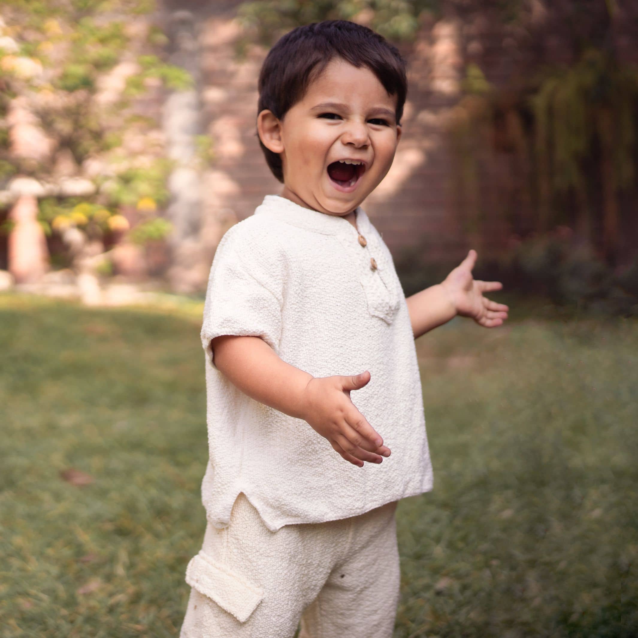 Happy Little boy wearing Luigi Short and Tron Bermuda made of knitted tanguis cotton by Liten Aventuris. | Lycklig liten pojke iförd Luigi-skjorta och Tron-bemudashorts gjorda av stickad tanguis bomull från Liten Aventuris. | Niño feliz vistiendo camisa luigi y bermuda Tronen algodón tanguis de Liten Aventuris.