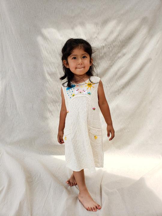 Liten Aventuris Collections. This Nira Dress is made of pure natural Peruvian tanguis cotton. So it's as comfy as it is stylish! It has a combination of geometric knitted patterns, two diagonal front pockets and decorative coconut buttons. With cute hand embroidery of colorful flowers, and friendly little animals, it's perfect for inspiring any little girl's imagination and bringing happiness to their wardrobe! Ethically made in Peru. Ekologisk klänning för flickor och bebisar.