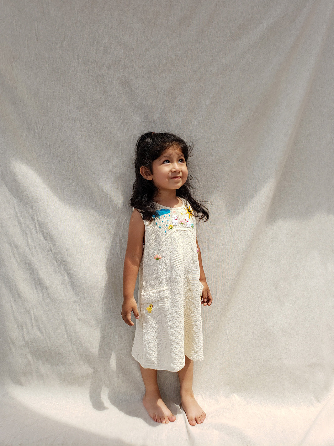 Liten Aventuris Collections. This Nira Dress is made of pure natural Peruvian tanguis cotton. So it's as comfy as it is stylish! It has a combination of geometric knitted patterns, two diagonal front pockets and decorative coconut buttons. With cute hand embroidery of colorful flowers, and friendly little animals, it's perfect for inspiring any little girl's imagination and bringing happiness to their wardrobe! Ethically made in Peru. Ekologisk klänning fÜr flickor och bebisar.