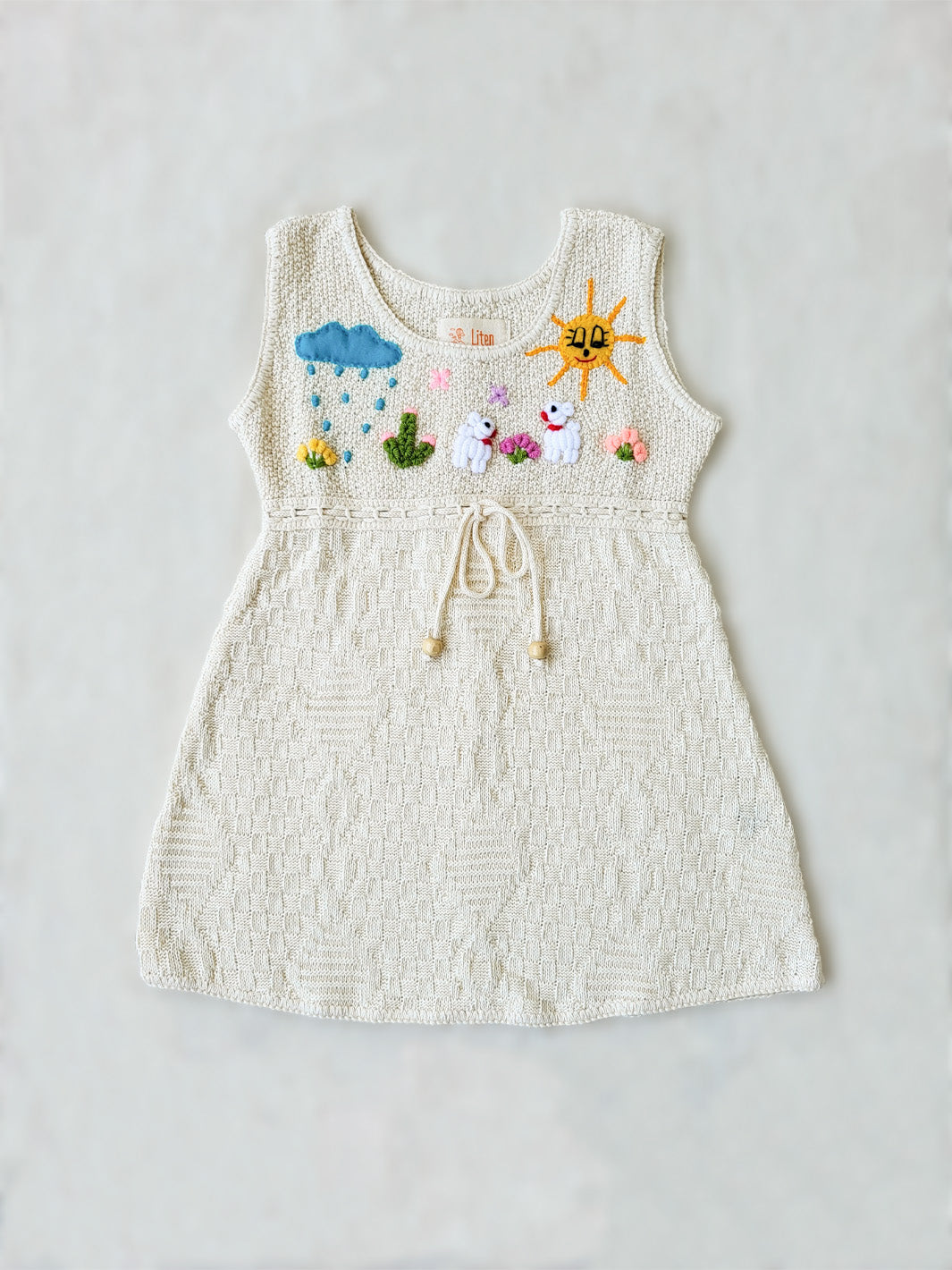 Liten Avevnturis Collections. Our Ăusta dress is the cutest look for your special little one! Delicately hand-embroidered, by Peruvian artisans, with adorable animals and elements from nature. Made in all Peruvian knitted tanguis cotton with delicately knitted terminations. Plus, the bottom part has a fun geometrical design that'll have your mini fashionista stand out from the crowd! Ethically made in Peru. Ekologisk klänning fĂśr flickor och bebisar.