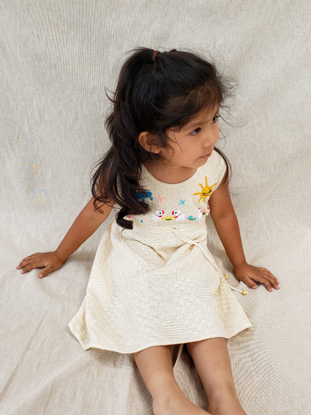 Liten Avevnturis Collections. Our Ăusta dress is the cutest look for your special little one! Delicately hand-embroidered, by Peruvian artisans, with adorable animals and elements from nature. Made in all Peruvian knitted tanguis cotton with delicately knitted terminations. Plus, the bottom part has a fun geometrical design that'll have your mini fashionista stand out from the crowd! Ethically made in Peru. Ekologisk klänning fĂśr flickor och bebisar.