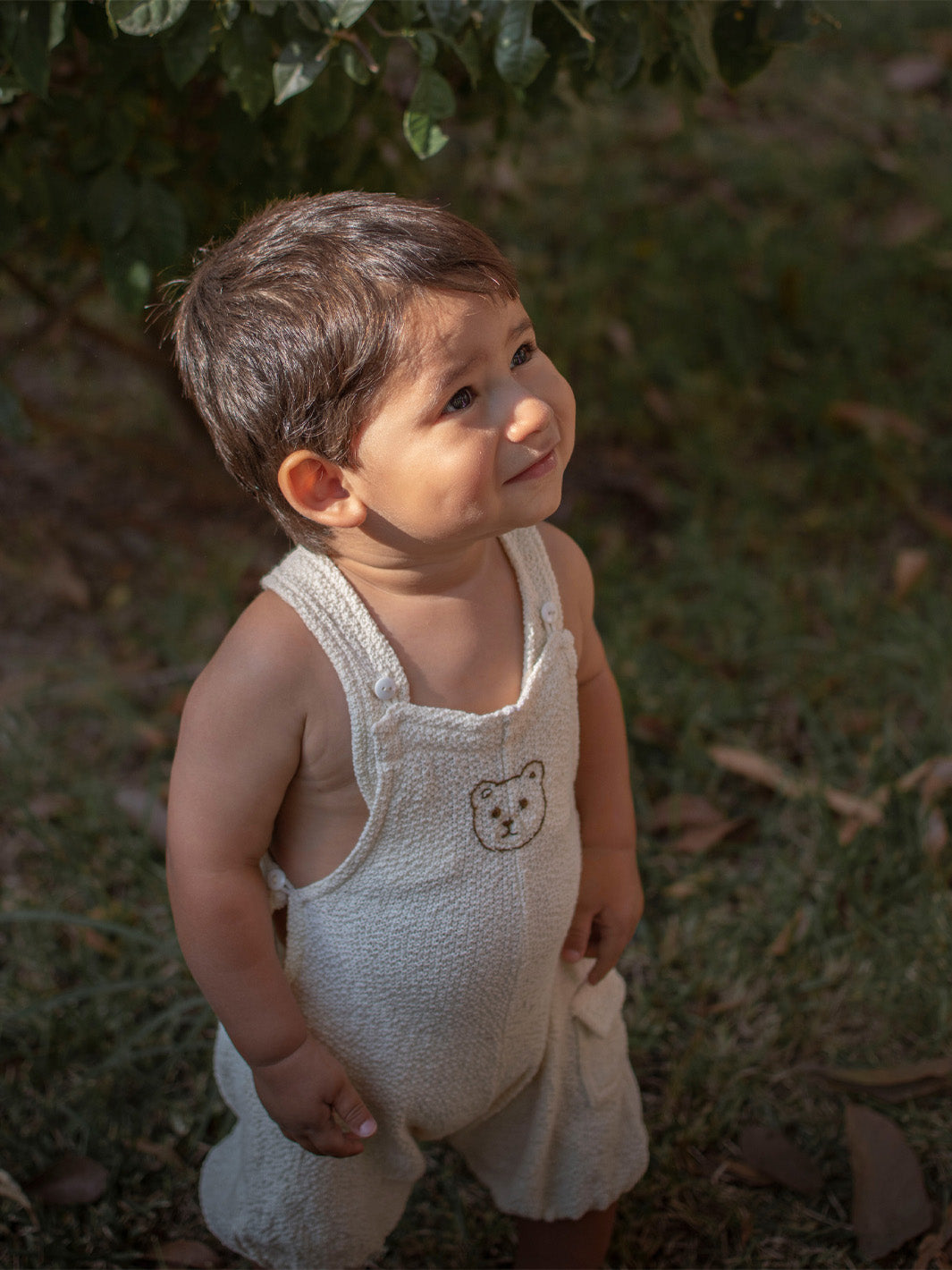 Liten Aventuris Collection. Keep your little one comfy and feeling like a bear cub in this Mico Overall! Crafted in natural knitted cotton with wooden buttons on the straps and a hand-embroidered bear on the front. The Mico overall has an elasticated leg opening for 1-Year-olds and a loose leg opening for bigger sizes. Plus one pocket for any tiny treasures. Perfect for boys and girls. Barnkläder, Bomullskläder, Natural kläder Hängselbyxor.