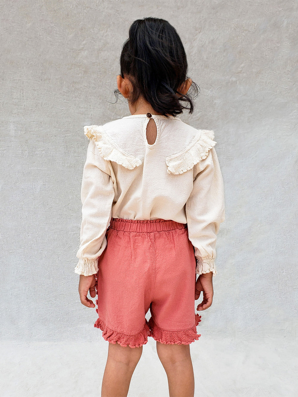 The beautiful Linn shorts are a wide-fit style. Perfect for climbing up trees or going on an adventure in the forest. Its lightweight cotton-knitted ruffles give the perfect light and artisanal touch. Flicka, Barn och Babis kläder. Barn kortbyxor, byxor, byxa. Combine with any other top from anny of our Liten Aventuris collections.