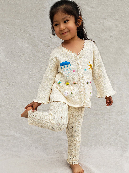 This Sandy Jacket is perfect for your little one's outdoor adventures! Our loose-fit jacket has hand-embroidered farm animals, flowers, and other nature-inspired design elements to give your stylish kid an extra-special look. Plus, two front pockets, and wooden buttons just for fun. Crafted with a combination of regular and geometrical knitted patterns. Liten Aventuris collections. Handbroderade barnkläder, Bomullsjacka, Barnjacka, Babyjacka.