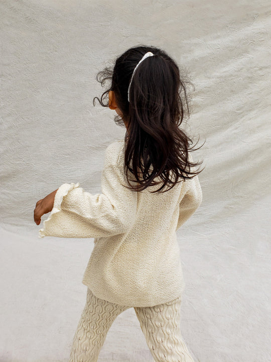 This Sandy Jacket is perfect for your little one's outdoor adventures! Our loose-fit jacket has hand-embroidered farm animals, flowers, and other nature-inspired design elements to give your stylish kid an extra-special look. Plus, two front pockets, and wooden buttons just for fun. Crafted with a combination of regular and geometrical knitted patterns. Liten Aventuris collections. Handbroderade barnkläder, Bomullsjacka, Barnjacka, Babyjacka.