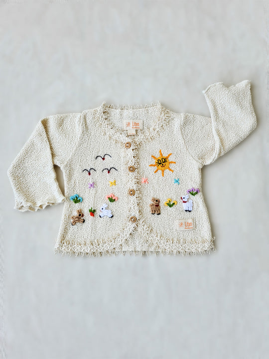 Crafted from soft Peruvian cotton and adorned with exquisite hand-embroidered animals, inspired by nature. Its wooden buttons and decorative knitted lace are the perfect finishing touches to this unique piece. Liten Aventuris Collections. Little adventurers will love playing in the outdoors with the Sol Jacket – crafted from soft Peruvian cotton and adorned with exquisite hand-embroidered animals, inspired by nature. Wooden buttons. Handbroderade barnkläder, Bomullsjacka, Barnjacka, Babyjacka.