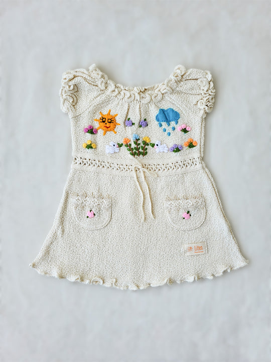 Liten Aventuris Collections. Let your little one shine like the sun in our Sol Dress! Perfect for summer days with its puffed sleeves, wavy edges, two pockets, and colorful hand-embroidered elements inspired by nature, farm animals, and – of course – the happy sun! The Sol dress is made of natural knitted Tanguis cotton. This dress is a comfy, stylish pick for your little explorer! Ethically made in Peru. Ekologisk klänning för flickor och bebisar.