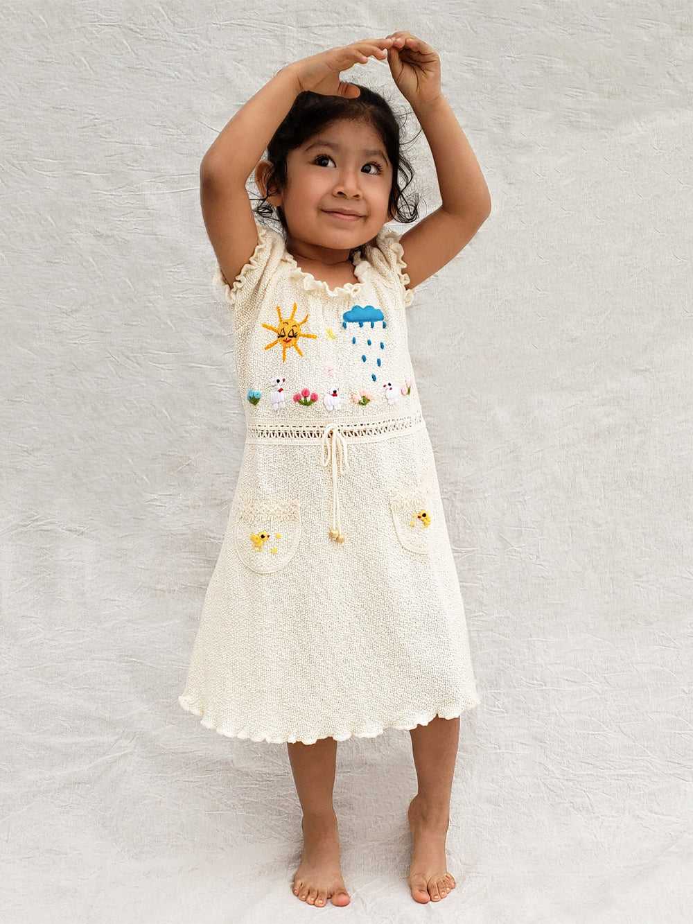 Liten Aventuris Collections. Let your little one shine like the sun in our Sol Dress! Perfect for summer days with its puffed sleeves, wavy edges, two pockets, and colorful hand-embroidered elements inspired by nature, farm animals, and â of course â the happy sun! The Sol dress is made of natural knitted Tanguis cotton. This dress is a comfy, stylish pick for your little explorer! Ethically made in Peru. Ekologisk klänning fĂśr flickor och bebisar.