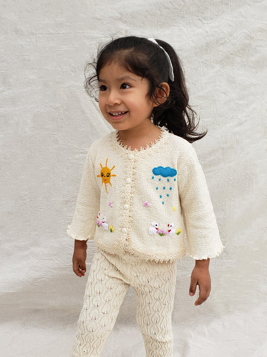 Crafted from soft Peruvian cotton and adorned with exquisite hand-embroidered animals, inspired by nature. Its wooden buttons and decorative knitted lace are the perfect finishing touches to this unique piece. Liten Aventuris Collections. Little adventurers will love playing in the outdoors with the Sol Jacket – crafted from soft Peruvian cotton and adorned with exquisite hand-embroidered animals, inspired by nature. Wooden buttons. Handbroderade barnkläder, Bomullsjacka, Barnjacka, Babyjacka.