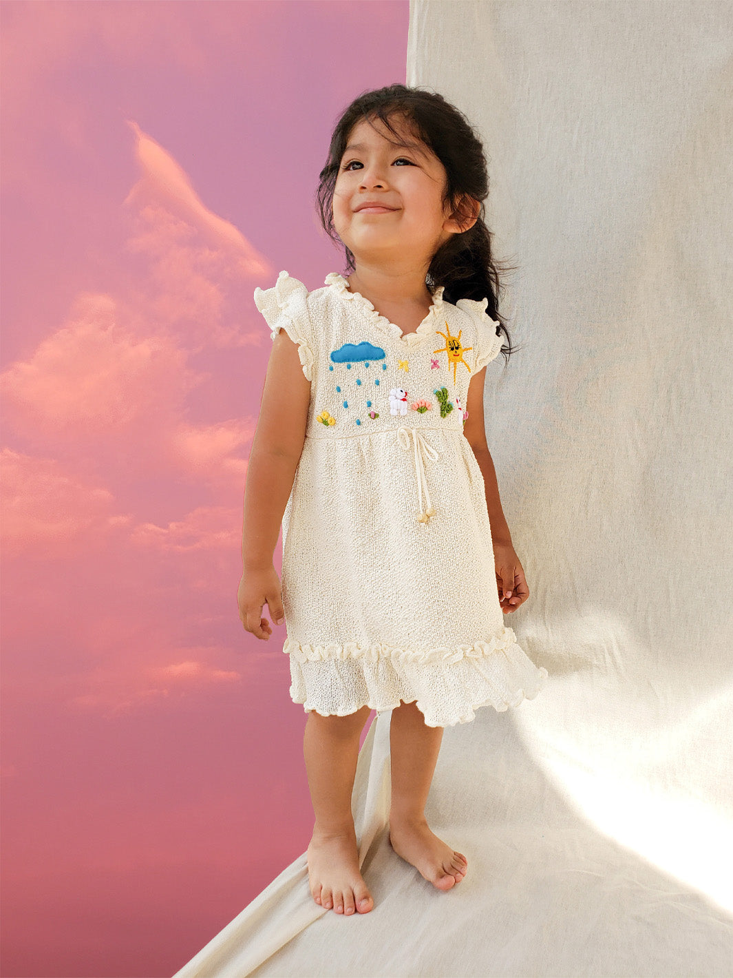 Liten Aventuris Collections. A dream fit for your little girl! Our Tanya Dress has an A-line fit and fun double-layer butterfly sleeves perfect for twirling and dancing. Made of knitted cotton fabric with hand embroidery inspired by nature. Embroidered by Peruvian artisans, this dress brings a touch of whimsy with its decorative fringe. Let your little one explore the world in style! Bomullsklänning fÜr babis och flickor.