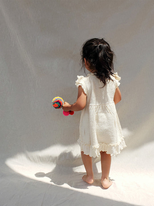 Liten Aventuris Collections. A dream fit for your little girl! Our Tanya Dress has an A-line fit and fun double-layer butterfly sleeves perfect for twirling and dancing. Made of knitted cotton fabric with hand embroidery inspired by nature. Embroidered by Peruvian artisans, this dress brings a touch of whimsy with its decorative fringe. Let your little one explore the world in style! Bomullsklänning för babis och flickor.