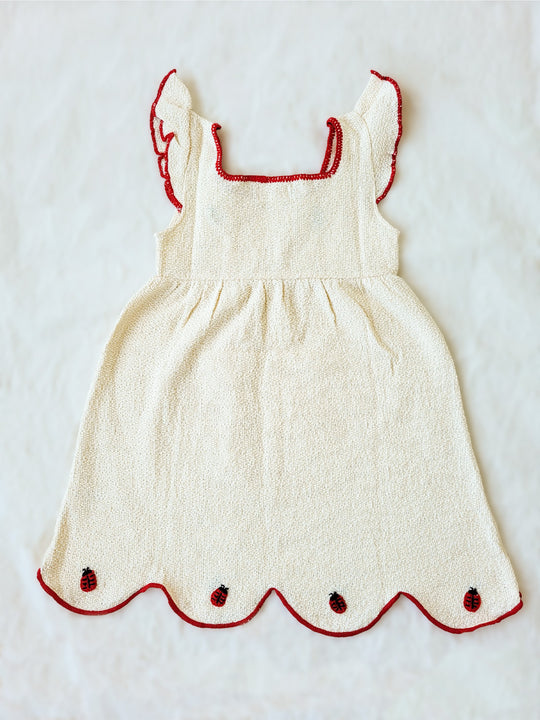 Liten Aventuris Collections. Bring luck and charm to your little one with this Zafirina dress! There's the belief in Italy that a ladybug brings good luck to the person it lands on. And we wanted to bring some luck to your little one. A knitted dress from Peruvian Cotton, and red knitted finishes bring a pop of color to this sweet garment. Hand-embroidered ladybugs playfully perch around the wavy-cut skirt, it's easy to see why Italy believes in good luck! Bomullsklänning fÜr babis och flickor.