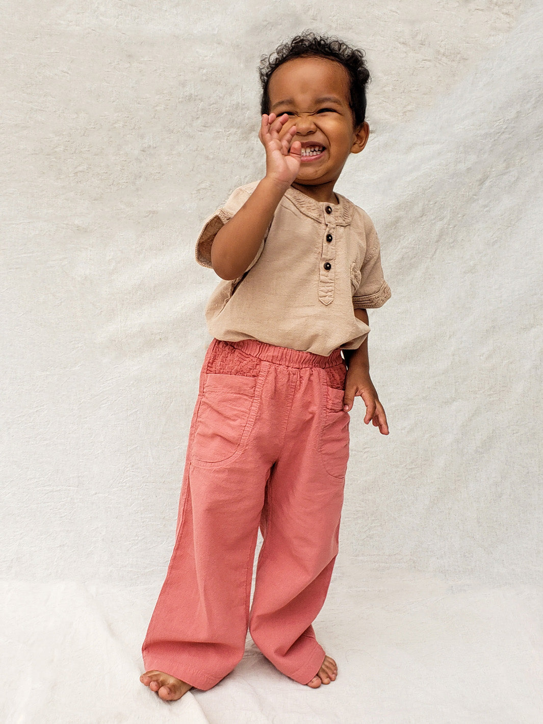 The Olve pants are light and very comfortable. Excellent for traveling or playing outside! These loose-fit pants provide freedom of movement. And the lateral pockets at the front are internally layered with a knitted-cotton pattern. This gives the perfect artisanal touch. Mix and match different outfits with any top from any of our Liten Aventuris collections. Unisex cotton pants. Barnkläder, Bomullskläder, Natural kläder. Flicka, pojken och babis kläder. Barn Byxor.