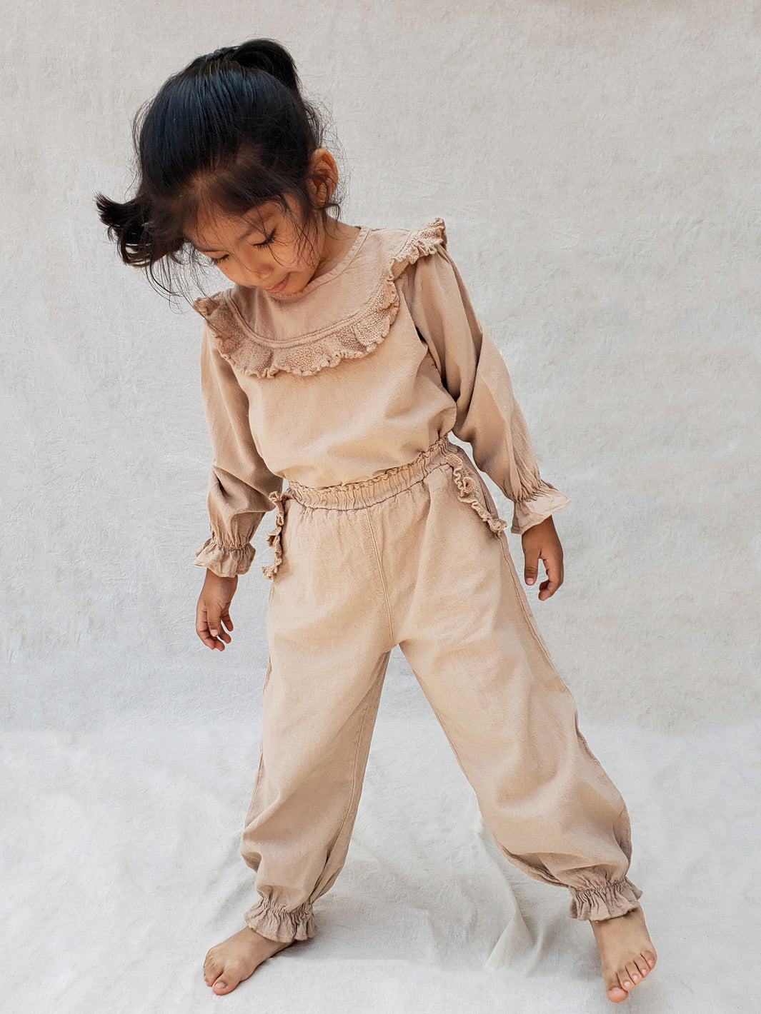 The Siri Pants are elegant and comfortable at the same time. These bloomer pants with ruffles at the bottom are perfect for a walk on the beach or a nice play date at the park. The Siri Pants bring two pockets with knitted cotton ruffles on them. It adds a nice artisanal touch. Beautiful, chic, and charming!  Make the perfect match with the Siri blouse. 100% Natural Peruvian Tocuyo Cotton. Perfect for girls. Barnkläder, Bomullskläder, Natural kläder. Flicka kläder. Barn Byxor.