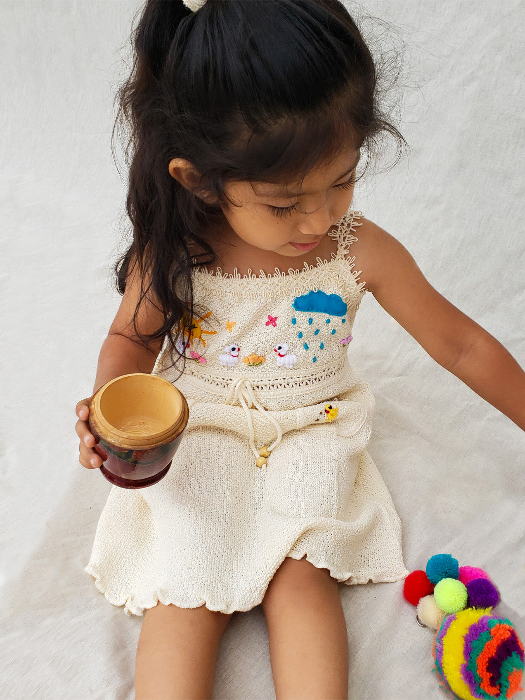 Liten Aventuris Collections. Dress your little star in this Estrella Dress! Featuring a strappy design, two front pockets with intricate cotton knitted lace, and colorful farm animal embroidery, your kiddo will be twinkling bright in no time! With its natural Peruvian Tanguis Cotton and star-inspired name, this dress will make your kids feel like they have the universe in their pocket! Ethically made in Peru. Ekologisk klänning för flickor och bebisar.