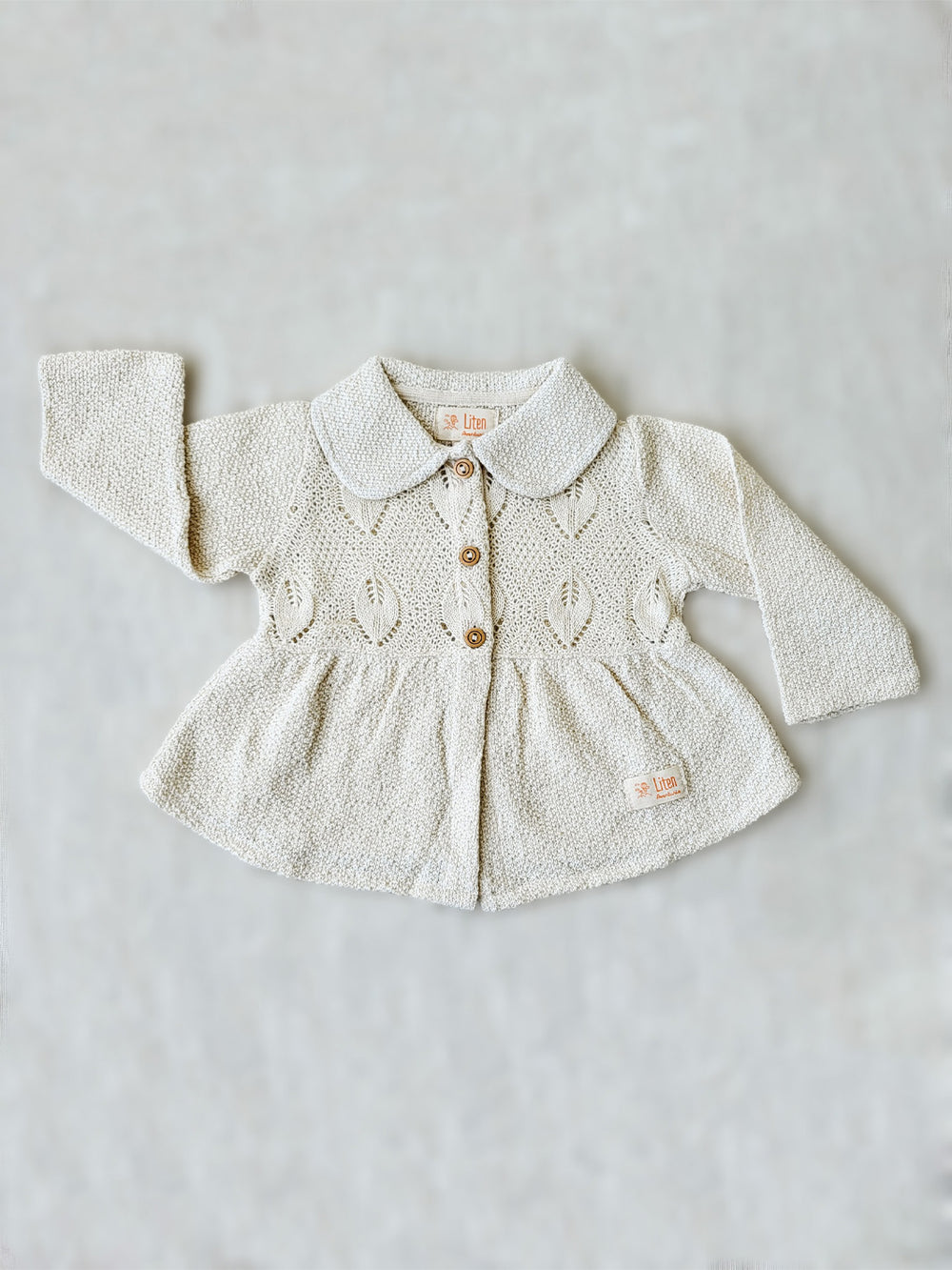 Our Ibis Jacket is the perfect addition to your little girl’s wardrobe! A beautifully crafted knitted jacket with a unique leaf-inspired pattern and captivating rounded flat collar. All in stylish A-fit silhouette with wooden buttons. She’ll look (and feel!) extra special in this elegant and one-of-a-kind piece! Liten Aventuris Colelctions. Bomullsjacka, Barnjacka, Babyjacka.