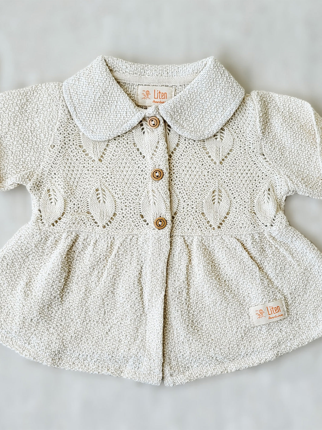 Our Ellen Jacket is the perfect addition to your little girl’s wardrobe! A beautifully crafted knitted jacket with a unique leaf-inspired pattern and captivating rounded flat collar. All in stylish A-fit silhouette with wooden buttons. She’ll look (and feel!) extra special in this elegant and one-of-a-kind piece! Liten Aventuris Colelctions. Bomullsjacka, Barnjacka, Babyjacka.