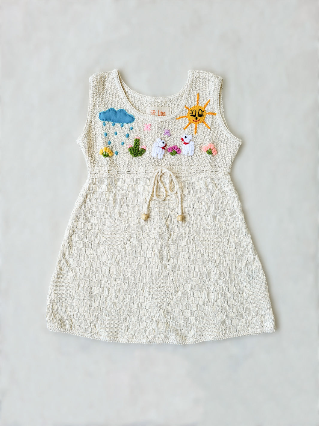 Liten Avevnturis Collections. Our Ñusta dress is the cutest look for your special little one! Delicately hand-embroidered, by Peruvian artisans, with adorable animals and elements from nature. Made in all Peruvian knitted tanguis cotton with delicately knitted terminations. Plus, the bottom part has a fun geometrical design that'll have your mini fashionista stand out from the crowd! Ethically made in Peru. Ekologisk klänning för flickor och bebisar.