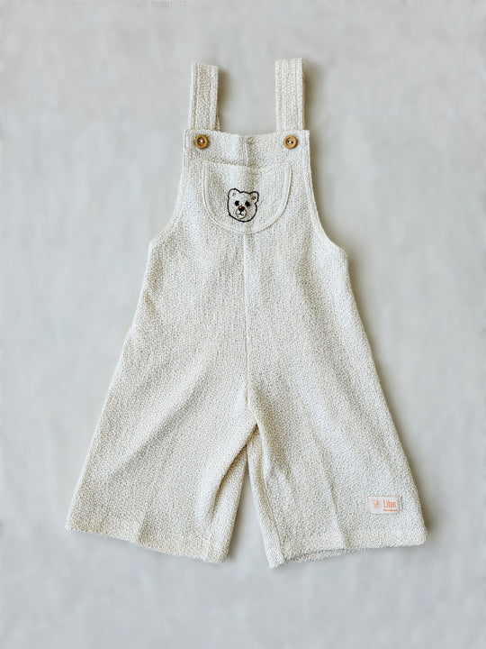 Liten Aventuris Collection. Keep your little one comfy and feeling like a bear cub in this Mico Overall! Crafted in natural knitted cotton with wooden buttons on the straps and a hand-embroidered bear on the front. The Mica overall has an elasticated leg opening for 1-Year-olds and a loose leg opening for bigger sizes. Plus one pocket for any tiny treasures. Perfect for boys and girls. Barnkläder, Bomullskläder, Natural kläder Hängselbyxor.