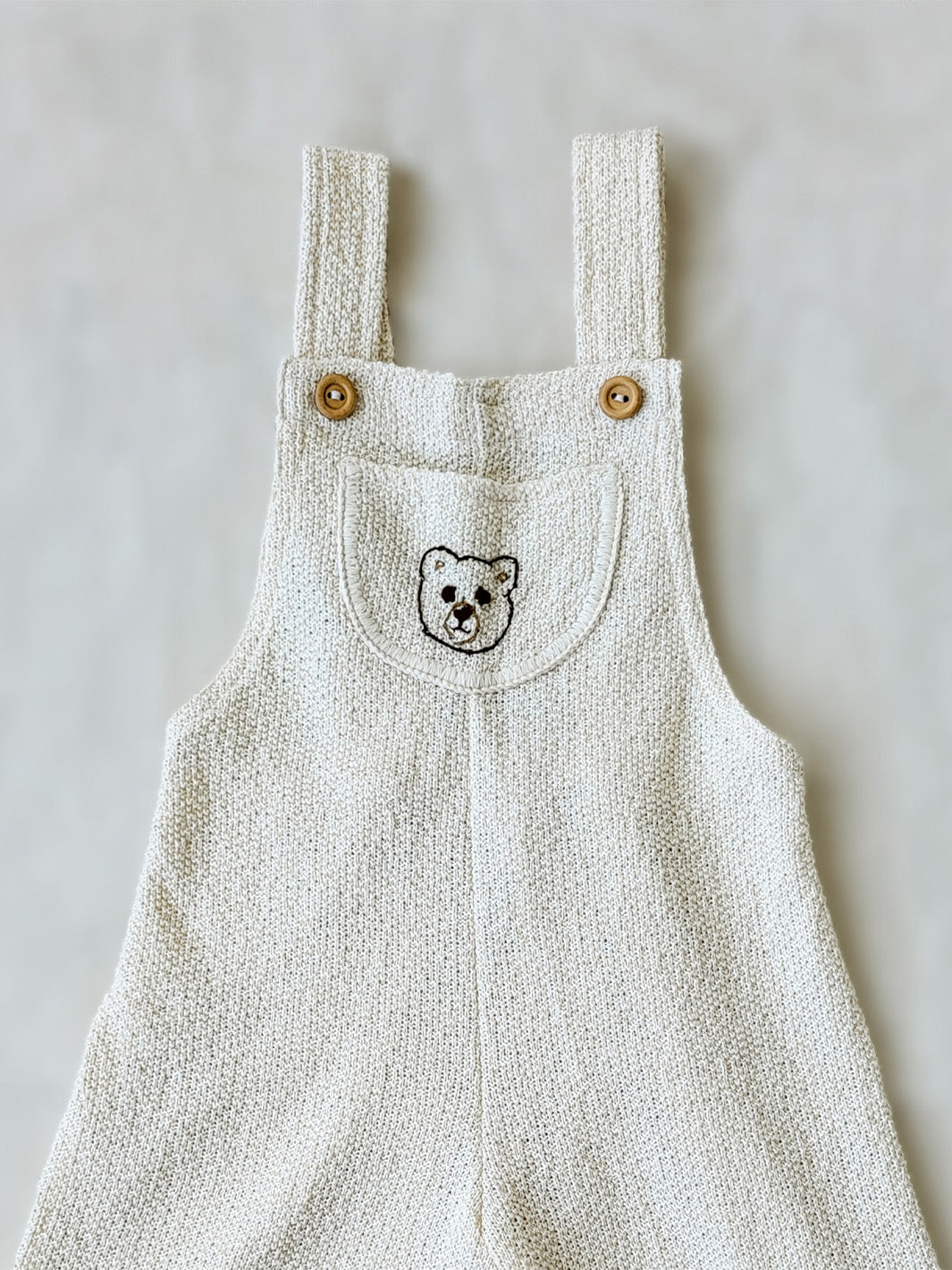 Liten Aventuris Collection. Keep your little one comfy and feeling like a bear cub in this Mico Overall! Crafted in natural knitted cotton with wooden buttons on the straps and a hand-embroidered bear on the front. The Mica overall has an elasticated leg opening for 1-Year-olds and a loose leg opening for bigger sizes. Plus one pocket for any tiny treasures. Perfect for boys and girls. Barnkläder, Bomullskläder, Natural kläder Hängselbyxor.