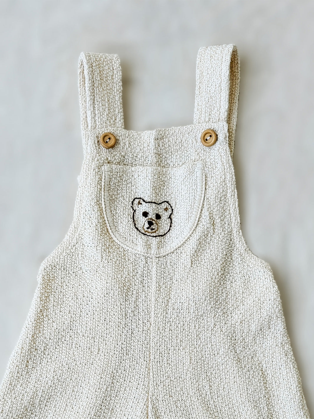 Liten Aventuris Collection. Keep your little one comfy and feeling like a bear cub in this Mico Overall! Crafted in natural knitted cotton with wooden buttons on the straps and a hand-embroidered bear on the front. The Mica overall has an elasticated leg opening for 1-Year-olds and a loose leg opening for bigger sizes. Plus one pocket for any tiny treasures. Perfect for boys and girls. Barnkläder, Bomullskläder, Natural kläder Hängselbyxor.