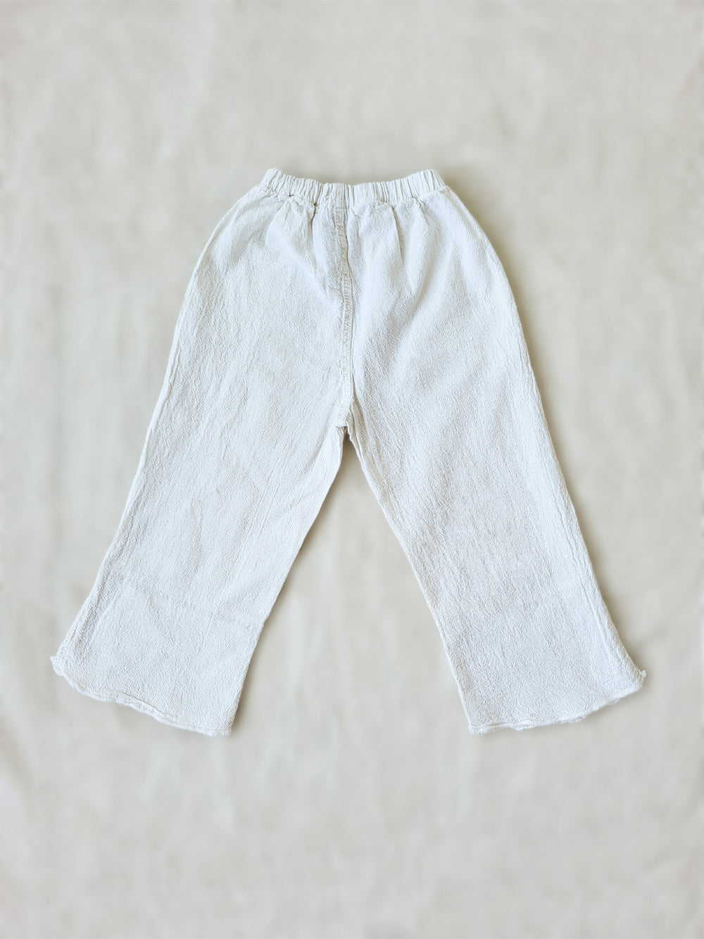 Liten Aventuris brand. Keep your little girl comfy and stylish in our Annie Pants! These natural cotton pants feature playful knitted cotton patterns at the bottom for added breeziness. With front pockets for keeping those special treasures! The soft material will keep your young one feeling silky. Pair this loose-fitting design with our Annie Blouse for the perfect winning combo! Flickan Byxor, Barns bomullskläder, svenska kläder, flickans byxor, ekologisk kläder, babis byxor.