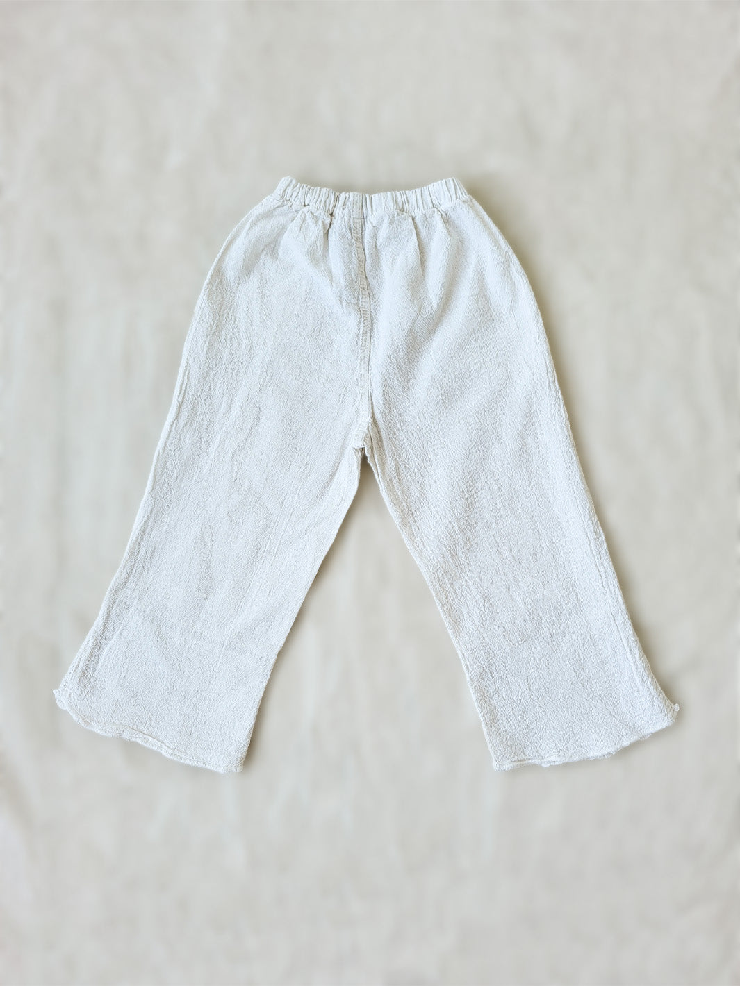 Liten Aventuris brand. Keep your little girl comfy and stylish in our Annie Pants! These natural cotton pants feature playful knitted cotton patterns at the bottom for added breeziness. With front pockets for keeping those special treasures! The soft material will keep your young one feeling silky. Pair this loose-fitting design with our Annie Blouse for the perfect winning combo! Flickan Byxor, Barns bomullskläder, svenska kläder, flickans byxor, ekologisk kläder, babis byxor.