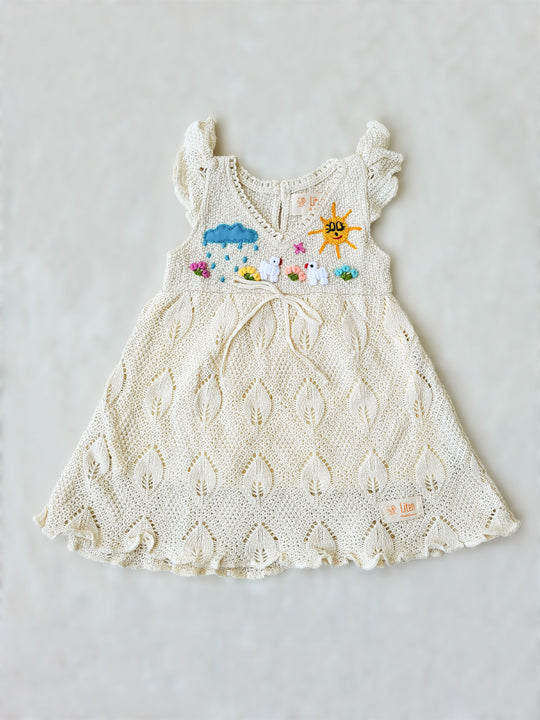 Explore the wild outdoors with your little one in the Pia Dress. Hand-embroidered with colorful designs inspired by farm animals and nature. Its cap sleeves and button behind the neck allow the perfect fit. This unique piece will spark your little one's imagination! A truly artisanal piece, with its natural cotton knitted pattern inspired by leaves and its inner layer in jersey cotton! Ekologisk klänning för flickor och bebisar.
