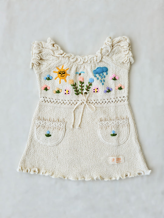 Liten Aventuris Collections. Let your little one shine like the sun in our Sol Dress! Perfect for summer days with its puffed sleeves, wavy edges, two pockets, and colorful hand-embroidered elements inspired by nature, farm animals, and – of course – the happy sun! The Sol dress is made of natural knitted Tanguis cotton. This dress is a comfy, stylish pick for your little explorer! Ethically made in Peru. Ekologisk klänning för flickor och bebisar.