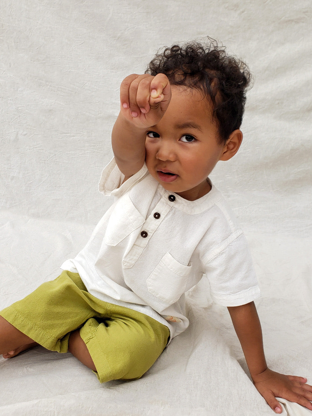 Liten Aventuris Natural Tocuyo Cotton shirt for kids. The Philipo shirt is perfect for a picnic at a lake or a nice morning stroll! This short sleeve shirt with coconut buttons and tunisian collar is casual and chic at the same time. This loose-fitting shirt with two pockets, is comfortable and soft with the skin. Ethically made in Peru. Bomullskläder, barnkläder, Pojken tröja, Skjortor, Natural kläder, ekologisk kläder.