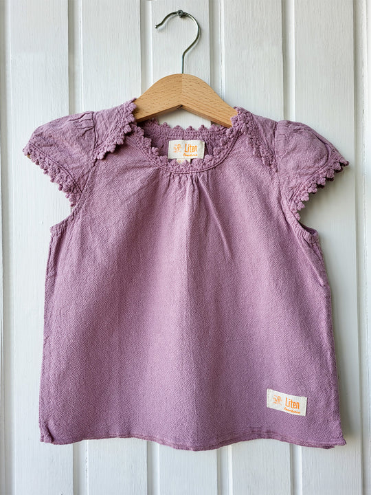 Liten Aventuris Natural Tocuyo Cotton blouse for kids. Our Lorin blouse is perfect for sunny days. With its loose-fitting shape and its embroidered detailed ribbon around the neck and sleeves, this blouse will be the best complement to any outfit! Perfect for girls. Barnkläder, Bomullskläder, Natural kläder. Flicka kläder. Flickblus. Barnblus.