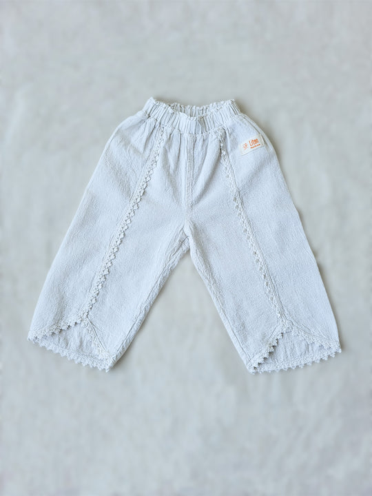 Liten Aventuris Natural Tocuyo Cotton pants for kids. Our Lorin pants are perfect for sunny days. With its loose-fitting size and soft elastic on the waist, toddlers and kids will feel comfortable and free. The Lorin pants bring an embroidered cotton decorative ribbon that will be the perfect match to our Lorin T-shirt! Perfect for girls. Barnkläder, Bomullskläder, Natural kläder. Flicka kläder. Barn Byxor.