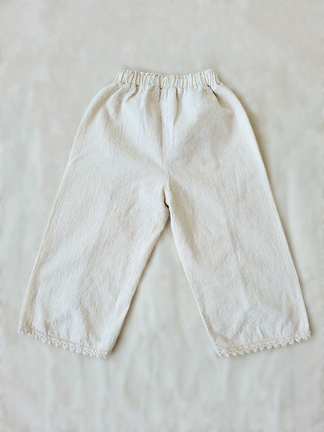 Liten Aventuris Natural Tocuyo Cotton pants for kids. Our Lorin pants are perfect for sunny days. With its loose-fitting size and soft elastic on the waist, toddlers and kids will feel comfortable and free. The Lorin pants bring an embroidered cotton decorative ribbon that will be the perfect match to our Lorin T-shirt! Perfect for girls. Barnkläder, Bomullskläder, Natural kläder. Flicka kläder. Barn Byxor.