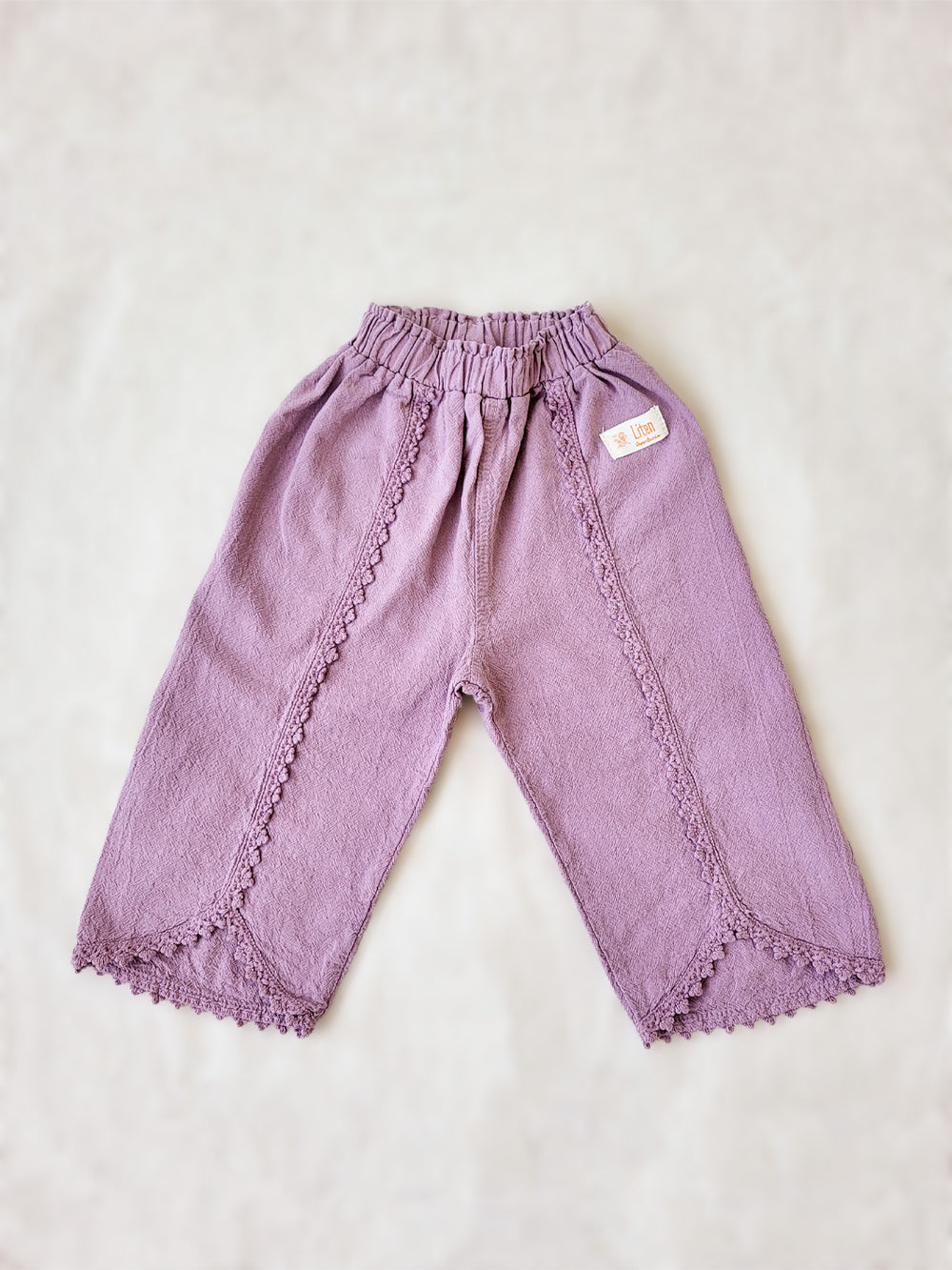 Liten Aventuris Natural Tocuyo Cotton pants for kids. Our Lorin pants are perfect for sunny days. With its loose-fitting size and soft elastic on the waist, toddlers and kids will feel comfortable and free. The Lorin pants bring an embroidered cotton decorative ribbon that will be the perfect match to our Lorin T-shirt! Perfect for girls. Barnkläder, Bomullskläder, Natural kläder. Flicka kläder. Barn Byxor.