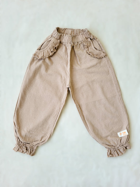 The Siri Pants are elegant and comfortable at the same time. These bloomer pants with ruffles at the bottom are perfect for a walk on the beach or a nice play date at the park. The Siri Pants bring two pockets with knitted cotton ruffles on them. It adds a nice artisanal touch. Beautiful, chic, and charming! Make the perfect match with the Siri blouse. 100% Natural Peruvian Tocuyo Cotton. Perfect for girls. Barnkläder, Bomullskläder, Natural kläder. Flicka kläder. Barn Byxor.