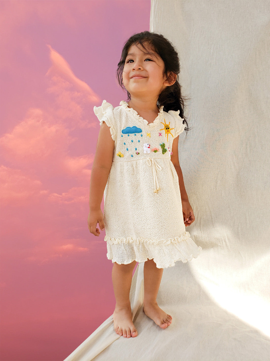 Liten Aventuris Collections. A dream fit for your little girl! Our Tanya Dress has an A-line fit and fun double-layer butterfly sleeves perfect for twirling and dancing. Made of knitted cotton fabric with hand embroidery inspired by nature. Embroidered by Peruvian artisans, this dress brings a touch of whimsy with its decorative fringe. Let your little one explore the world in style! Bomullsklänning för babis och flickor.