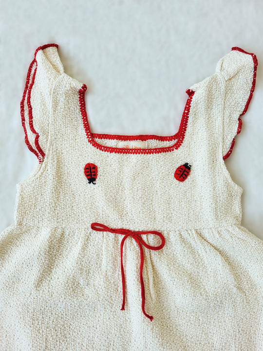 Liten Aventuris Collections. Bring luck and charm to your little one with this Zafirina dress! There's the belief in Italy that a ladybug brings good luck to the person it lands on. And we wanted to bring some luck to your little one. A knitted dress from Peruvian Cotton, and red knitted finishes bring a pop of color to this sweet garment. Hand-embroidered ladybugs playfully perch around the wavy-cut skirt, it's easy to see why Italy believes in good luck! Bomullsklänning för babis och flickor.