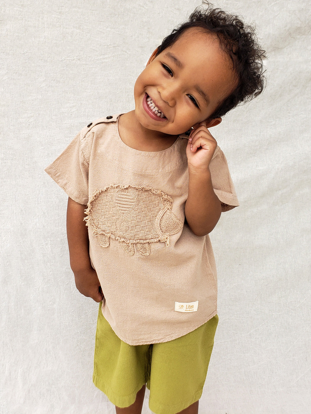 Liten Aventuris Natural Tocuyo Cotton t-shirt for kids. Kirpi is a cute little porcupine embroidered in knitted natural tanguis cotton. Our skilled artisans handcrafted Kirpi with care and attention to detail. Our lovely Kirpi T-shirt is a loose-fitting garment with coconut buttons. The opening on the shoulders makes the kid more comfortable when dressing up. Ethically made in Peru. Bomullskläder, barnkläder, Pojken & flickan tröja, Natural kläder, ekologisk kläder. Skjortor.