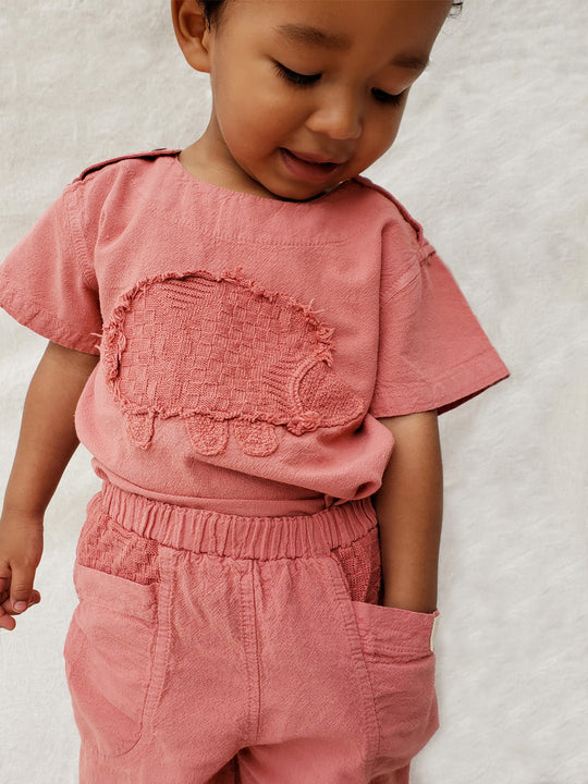 Liten Aventuris Natural Tocuyo Cotton t-shirt for kids. Kirpi is a cute little porcupine embroidered in knitted natural tanguis cotton. Our skilled artisans handcrafted Kirpi with care and attention to detail. Our lovely Kirpi T-shirt is a loose-fitting garment with coconut buttons. The opening on the shoulders makes the kid more comfortable when dressing up. Ethically made in Peru. Bomullskläder, barnkläder, Pojken & flickan tröja, Natural kläder, ekologisk kläder. Skjortor.